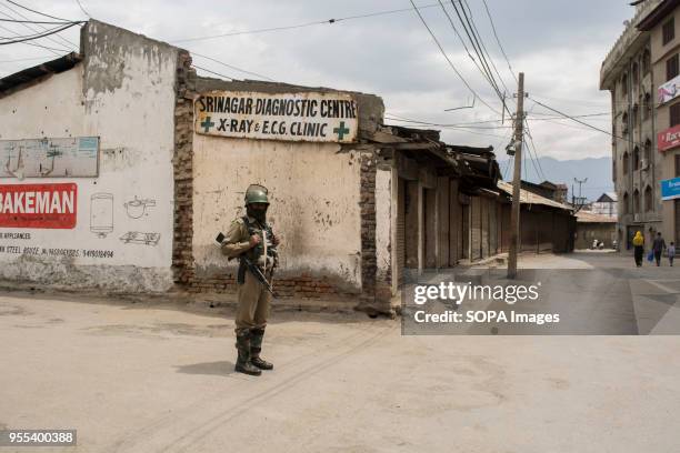 An Indian paramilitary trooper stands alert during the restrictions imposed by authorities in Srinagar, the summer capital of Indian controlled...