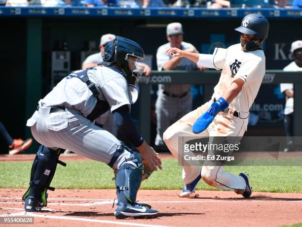 Whit Merrifield of the Kansas City Royals slides into home to score past Grayson Greiner of the Detroit Tigers in the first inning at Kauffman...