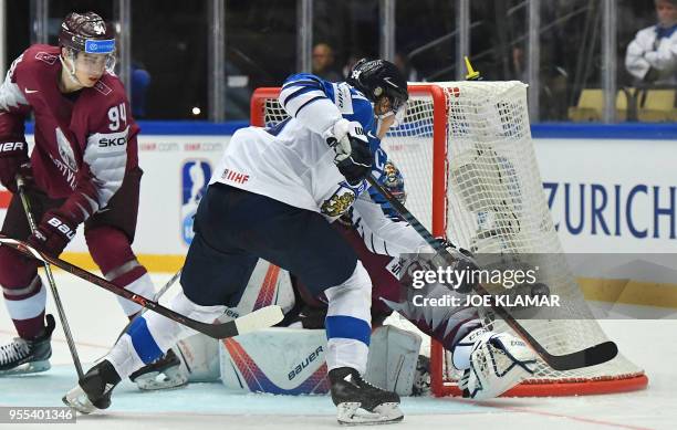 Latvia's goalkeeper Kristers Gudlevskis stops Finland's Mikael Granlund during the group B match Latvia vs Finland of the 2018 IIHF Ice Hockey World...