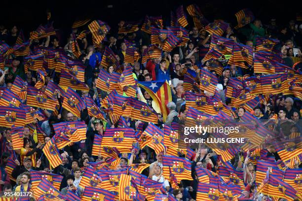 Woman waves a Catalan pro-independence Estelada flag among Barcelona flags during the Spanish league football match between FC Barcelona and Real...