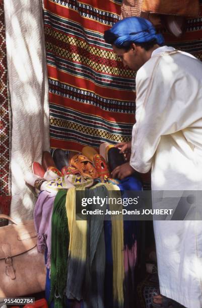 Marchand de babouches en cuir dans le souk de Marrakech, Maroc.