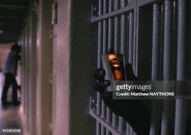 Un prisonnier observe le couloir de la prison depuis sa cellule grâce à son petit miroir durant la guerre civile en 1979 au Nicaragua.