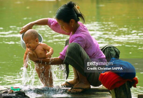 Femme donnant le bain à son bébé dans le lac Inlé, état de Shan, Birmanie .