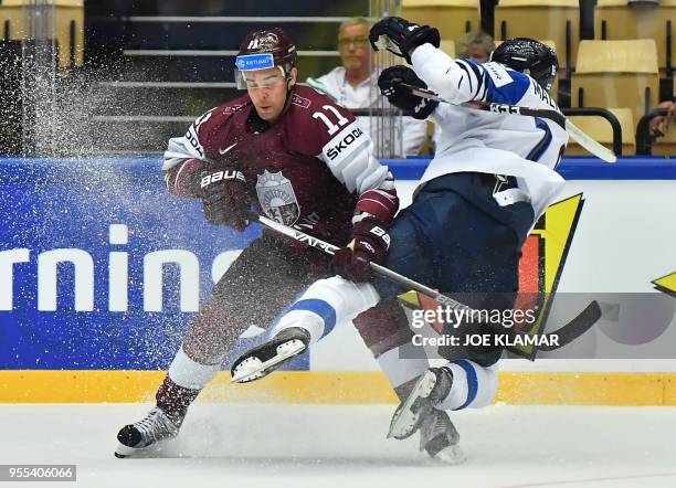 Finland's Saku Maenalanen fights for the puck with Latvia's Kristaps Sotnieks during the group B match Latvia vs Finland of the 2018 IIHF Ice Hockey...