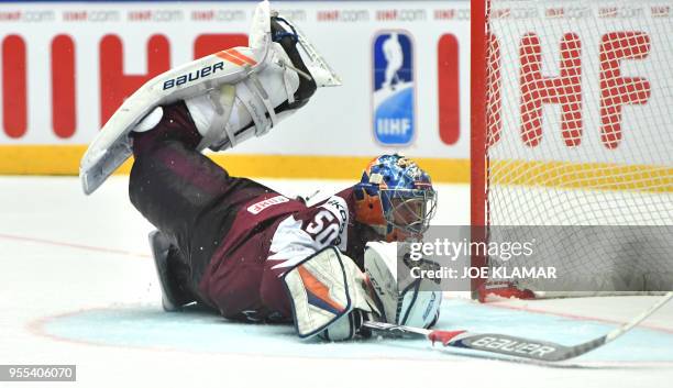 Latvia's goalkeeper Kristers Gudlevskis falls down after a puck during the group B match Latvia vs Finland of the 2018 IIHF Ice Hockey World...