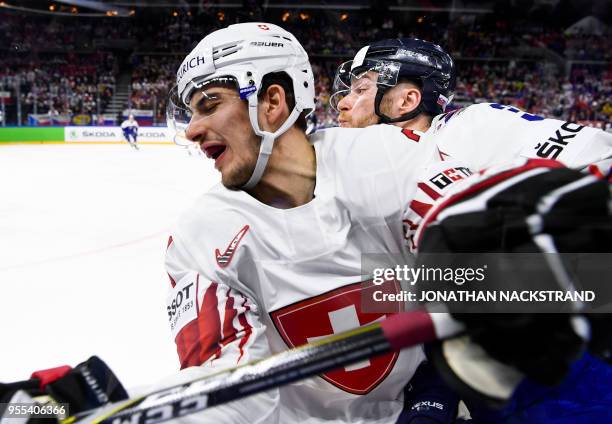 Finland's Saku Maenalanen fights for the puck with Latvia's Kristaps Sotnieks during the group A match Slovakia vs Switzerland of the 2018 IIHF Ice...