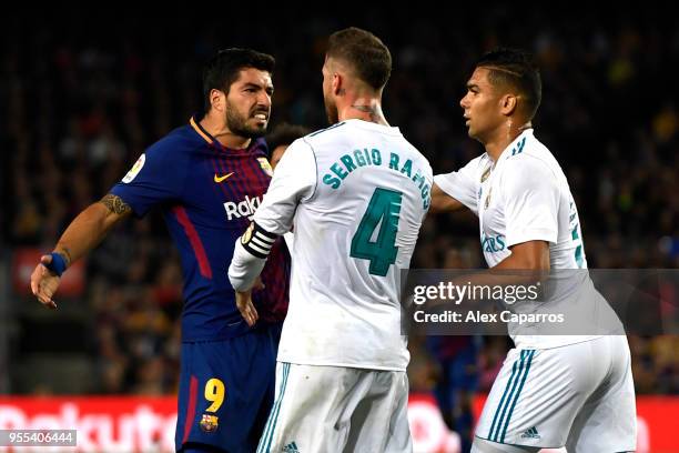 Luis Suarez of Barcelona clashes with Sergio Ramos and Casemiro of Real Madrid during the La Liga match between Barcelona and Real Madrid at Camp Nou...