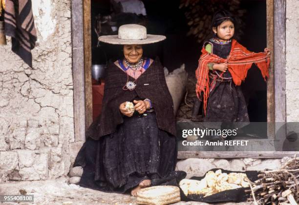 Paysanne décortiquant le maïs à l'entrée de sa maison à Saraguro, Equateur.