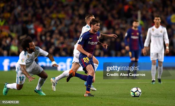 Sergi Roberto of Barcelona evades Toni Kroos and Marcelo of Real Madrid during the La Liga match between Barcelona and Real Madrid at Camp Nou on May...