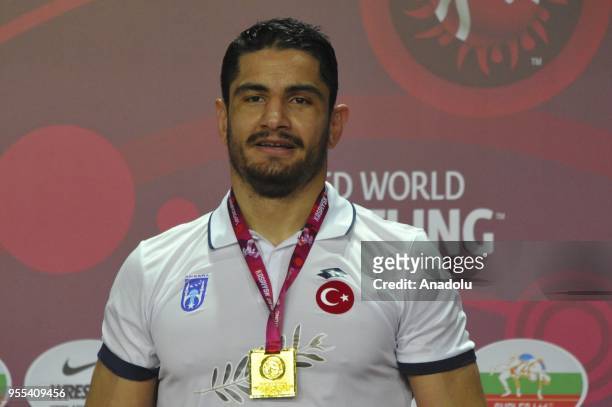 Turkish wrestler Taha Akgul poses during a medal ceremony after he won the gold medal in European Wrestling Championship after beating his Georgian...