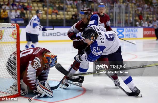 Kristaps Sotnieks of Latvia and Mikael Granlund of Finland battle for the puck during the 2018 IIHF Ice Hockey World Championship group stage game...
