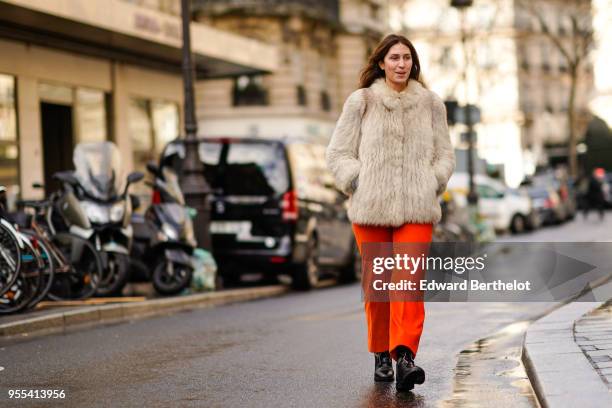 Guest wears a white fur coat, orange pants, black leather shoes, during Paris Fashion Week - Menswear Fall Winter 2018-2019, on January 19, 2018 in...