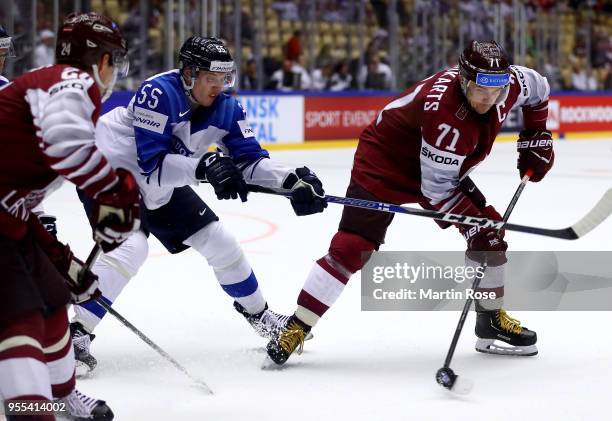 Roberts Bukarts of Latvia and Miika Koivisto of Finland battle for the puck during the 2018 IIHF Ice Hockey World Championship group stage game...