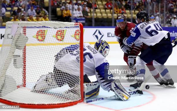Gints Meija of Latvia and Mikael Granlund of Finland battle for the puck during the 2018 IIHF Ice Hockey World Championship group stage game between...