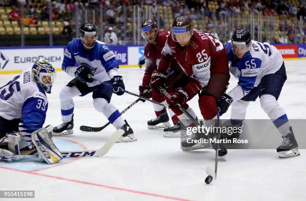 Andris Dzerins of Latvia and Miika Koivisto of Finland battle for the puck during the 2018 IIHF Ice Hockey World Championship group stage game...