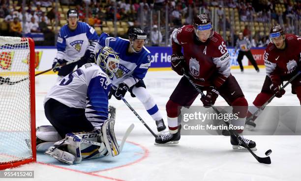 Andris Dzerins of Latvia fails to score over Ville Husso, goaltender of Finland battle during the 2018 IIHF Ice Hockey World Championship group stage...