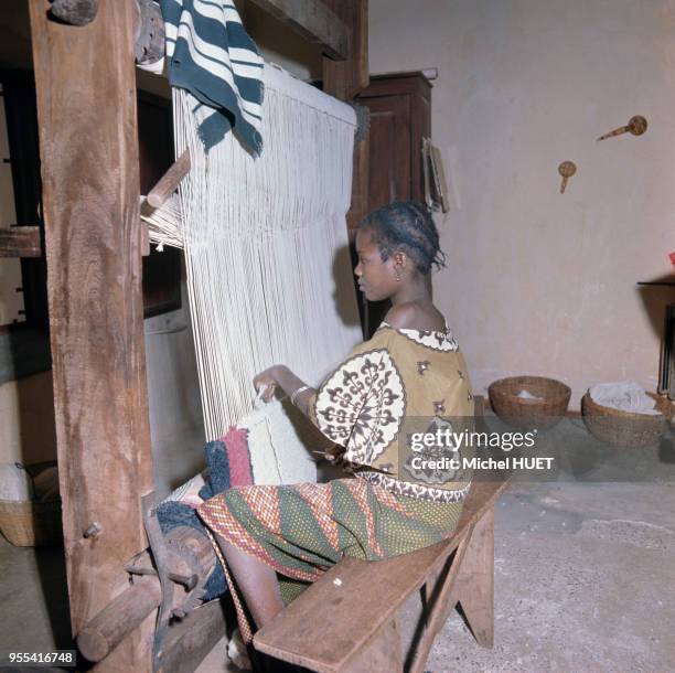 Jeune femme travaillant sur un métier à tisser dans une fabrique de tapis à Ségou, Mali.