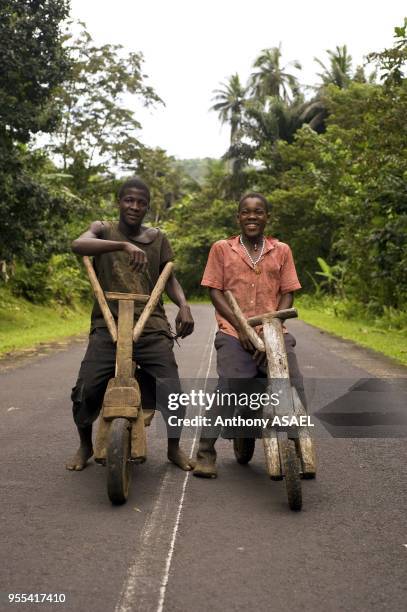 Deux adolescents africains conduisant une bicyclette en bois fabriquee a la main le 20 octobre 2009 dans l'ile de Sao Tome, Republique democratique...