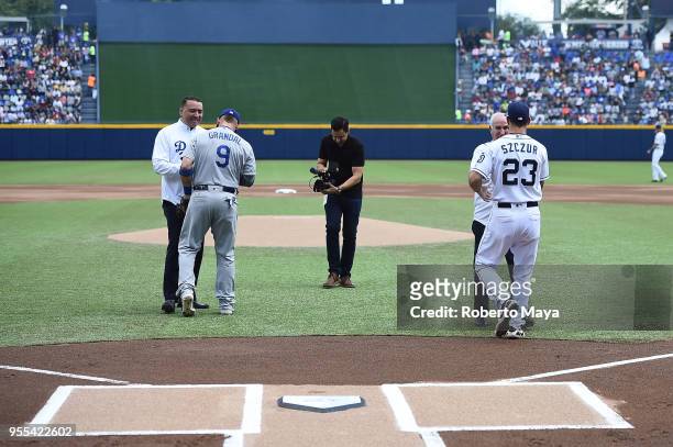 José Maiz and Willie González shake hands with Yasmani Grandal of the Los Angeles Dodgers and Matt Szczur of the San Diego Padres after throwing out...