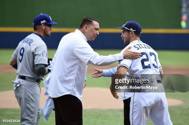 Willie González shakes hands with Matt Szczur of the San Diego Padres after throwing out the ceremonial first pitch prior to the game between the Los...