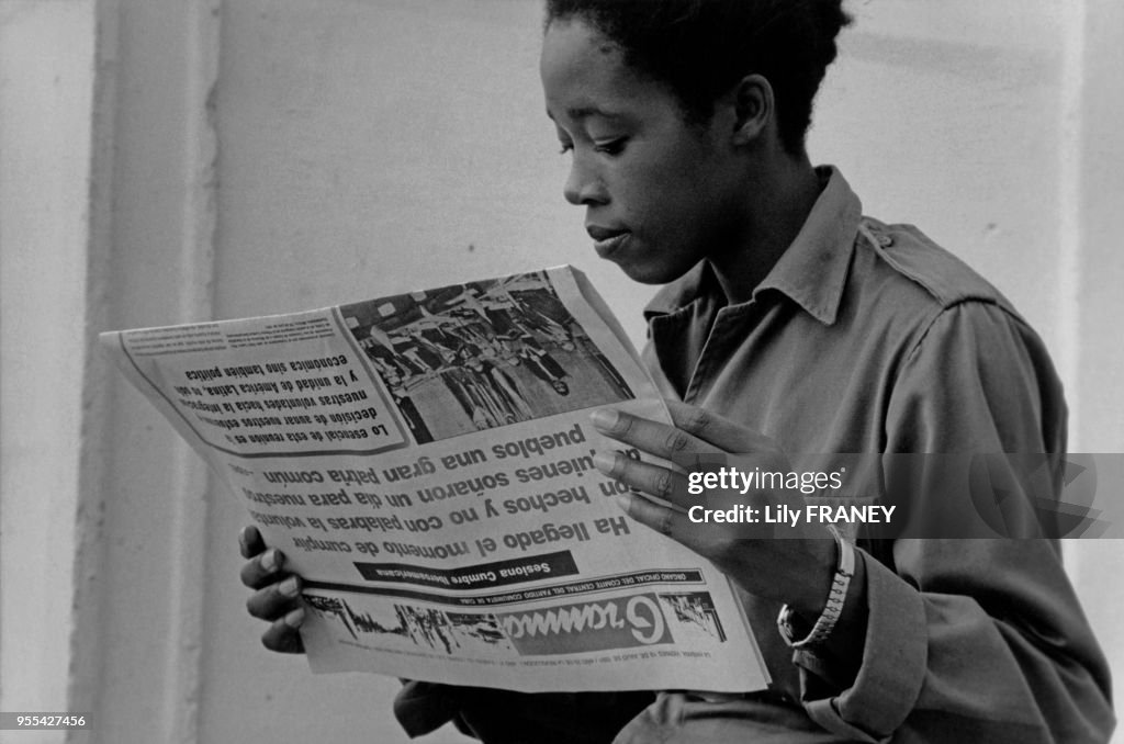 Jeune femme soldat lisant le journal à la Havane