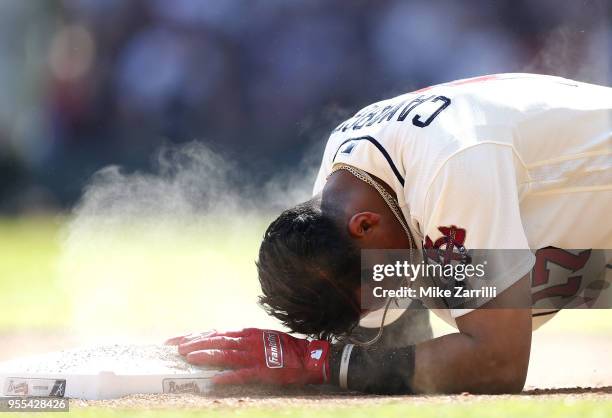 Shortstop Johan Camargo slides back into third base in the ninth inning during the game against the San Francisco Giants at SunTrust Park on May 6,...