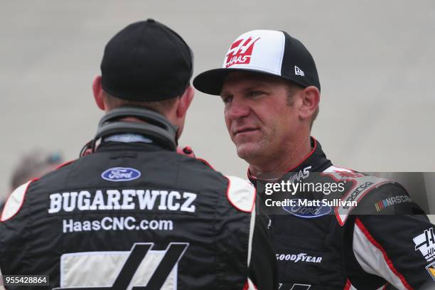Clint Bowyer, driver of the Haas Automation Demo Day Ford, talks with his crew chief, Mike Bugarewicz, during a rain delay for the Monster Energy...