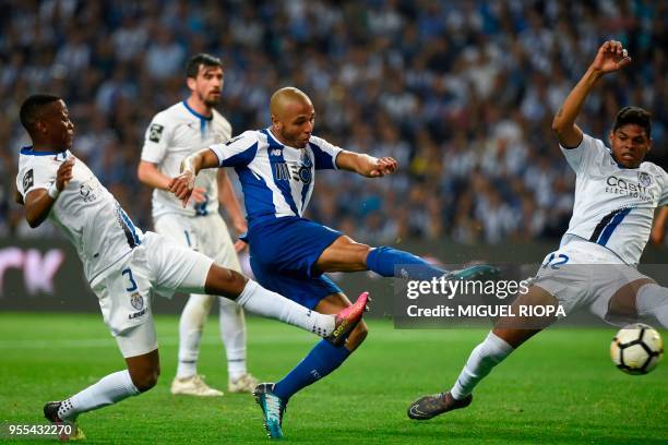 Porto's Algerian forward Yacine Brahimi scores a goal past Feirense's Ugandan defender Alex Kakuba and Brazilian defender Flavio Ramos during the...