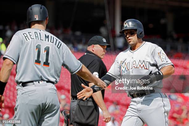Martin Prado and J.T. Realmuto of the Miami Marlins celebrate after scoring runs following a single by Starlin Castro in the first inning against the...