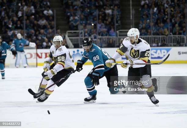 Mikkel Boedker of the San Jose Sharks goes for the puck against Erik Haula and Shea Theodore of the Vegas Golden Knights during Game Four of the...