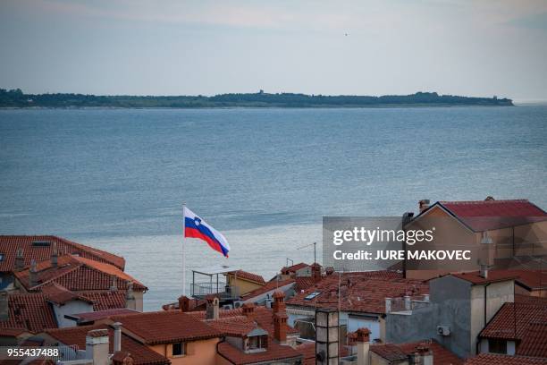 Slovenia's flag is seen fluttering above the roofs in Piran, Slovenia on May 6, 2018.