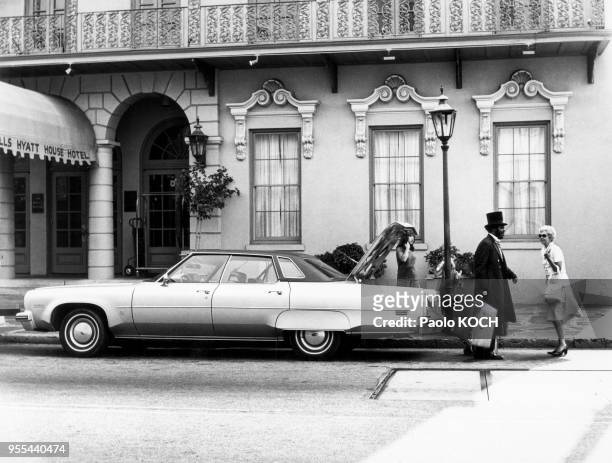 Portier d'un hôtel déchargeant une voiture à Charleston, en Caroline du Sud, en 1976, Etats-Unis.