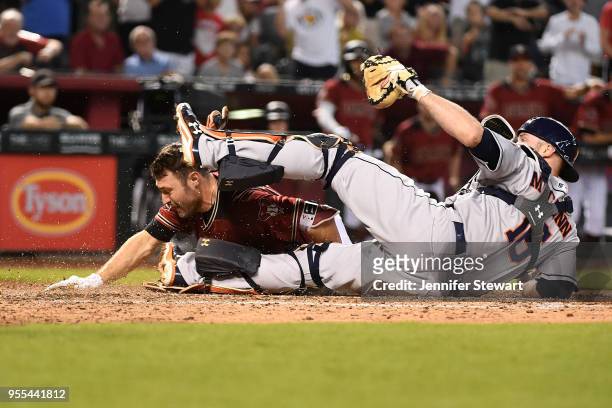 Pollock of the Arizona Diamondbacks slides into home plate against Brian McCann of the Houston Astros to score on an interference error by Alex...