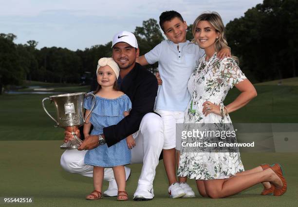 Jason Day of Australia and his wife Ellie pose with their children, Dash and Lucy, on the 18th green after winning the 2018 Wells Fargo Championship...