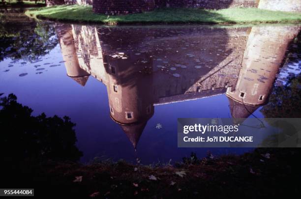 Le reflet du château d'Ainay-le-Vieil dans les douves, dans le Cher, France.