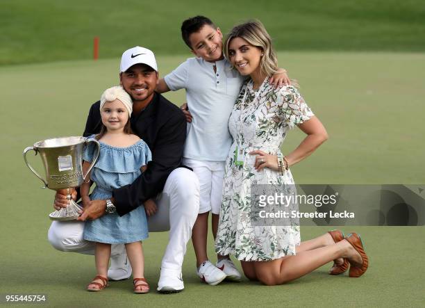 Jason Day of Australia and his wife Ellie pose with their children, Dash and Lucy, on the 18th green after winning the 2018 Wells Fargo Championship...