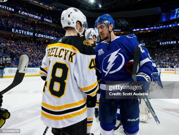 Ryan McDonagh of the Tampa Bay Lightning celebrates the series win and shakes hands with Matt Grzelcyk of the Boston Bruins during Game Five of the...