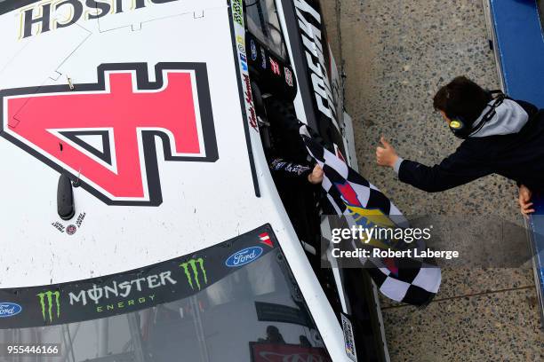 Kevin Harvick, driver of the Jimmy John's Ford, celebrates with a fan after winning the Monster Energy NASCAR Cup Series AAA 400 Drive for Autism at...