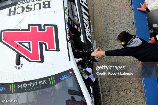 Kevin Harvick, driver of the Jimmy John's Ford, celebrates with a fan after winning the Monster Energy NASCAR Cup Series AAA 400 Drive for Autism at...