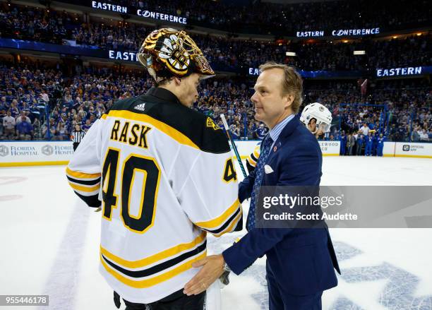 Head Coach Jon Cooper of the Tampa Bay Lightning celebrates the series win and shakes hands with Tuukka Rask of the Boston Bruins during Game Five of...