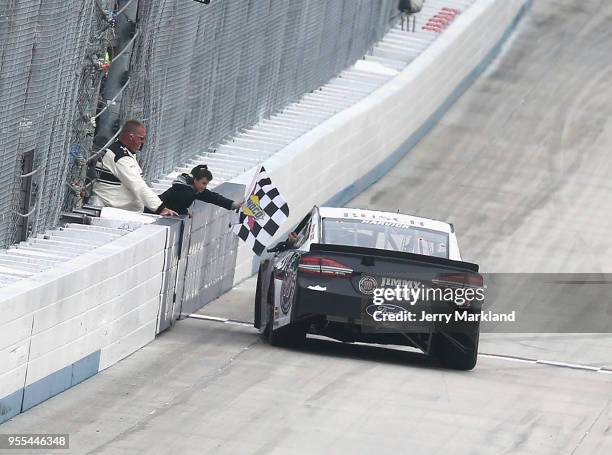 Kevin Harvick, driver of the Jimmy John's Ford, celebrates with a fan as he is handed the checkered flag after winning the Monster Energy NASCAR Cup...