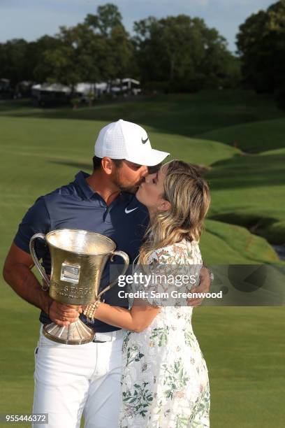 Jason Day of Australia and his wife Ellie pose with the trophy on the 18th green after winning the 2018 Wells Fargo Championship at Quail Hollow Club...