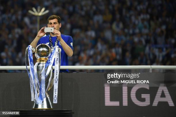 Porto's Spanish goalkeeper Iker Casillas takes a picture of the trophy after winning the league title following the Portuguese league football match...