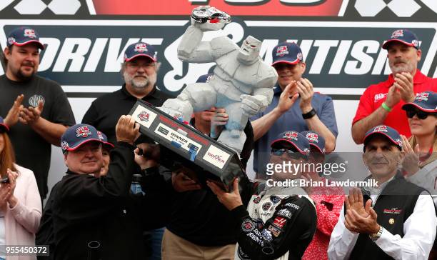 Kevin Harvick, driver of the Jimmy John's Ford, celebrates with the trophy in victory lane after winning the Monster Energy NASCAR Cup Series AAA 400...