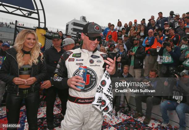 Kevin Harvick, driver of the Jimmy John's Ford, talks on the phone with his son, Keelan, in victory lane after winning the Monster Energy NASCAR Cup...