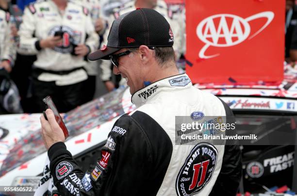 Kevin Harvick, driver of the Jimmy John's Ford, talks on the phone with his son, Keelan, in victory lane after winning the Monster Energy NASCAR Cup...