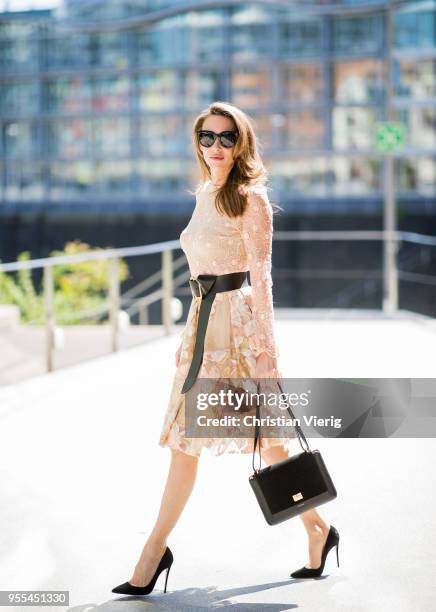 Alexandra Lapp wearing a lace embroidered mini dress by Lana Mueller, a gold buckle belt by Dorothee Schuhmacher, a numero deux edition in trio black...
