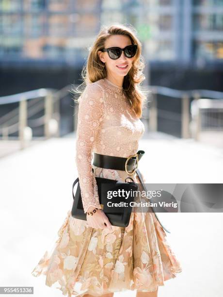 Alexandra Lapp wearing a lace embroidered mini dress by Lana Mueller, a gold buckle belt by Dorothee Schuhmacher, a numero deux edition in trio black...