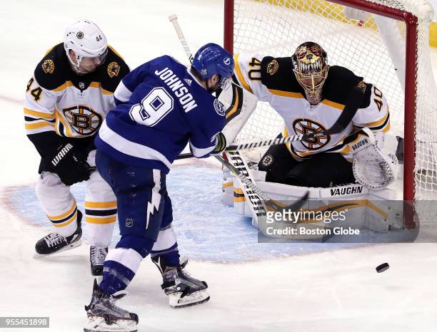 Tampa Bay Lightning center Tyler Johnson shoots a wide shot as he is held up by Boston Bruins defenseman Nick Holden during the third period. Tampa...