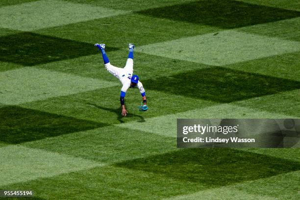 Dee Gordon of the Seattle Mariners flies through the air after making a long throw to third base on a single by Luis Valbuena of the Los Angeles...